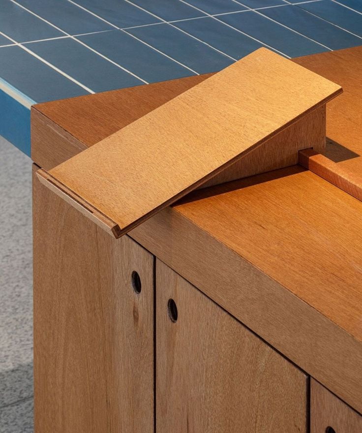 Close-up of a solid wood joint resting on blue tiling.
