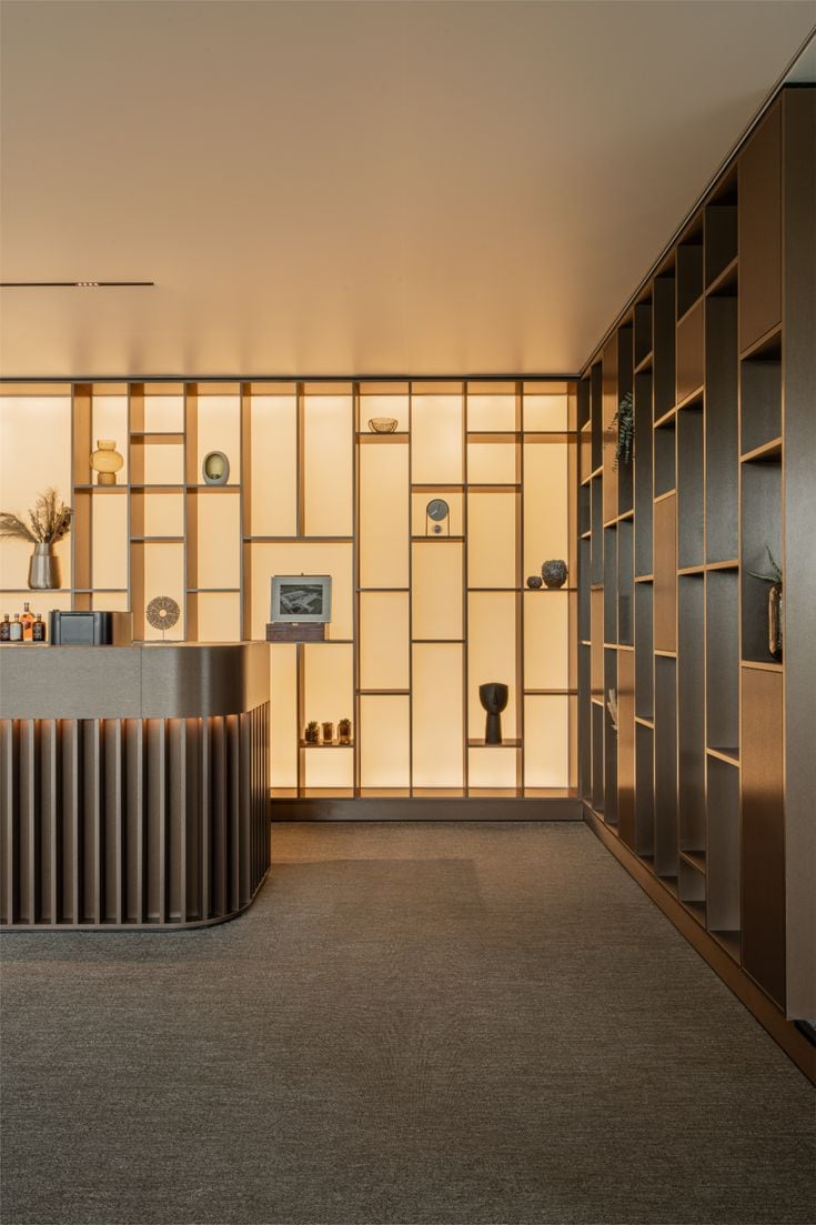 Showroom: reception counter and backlit pale wood shelving.